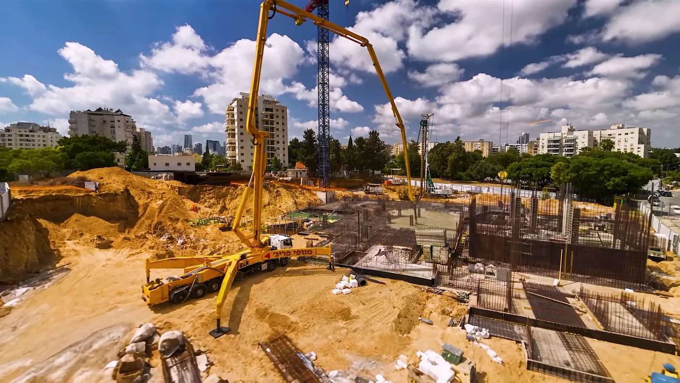 משאבת בטון ביציקת היסודות, עם ברזלי הזיון והמרתף בחפירה